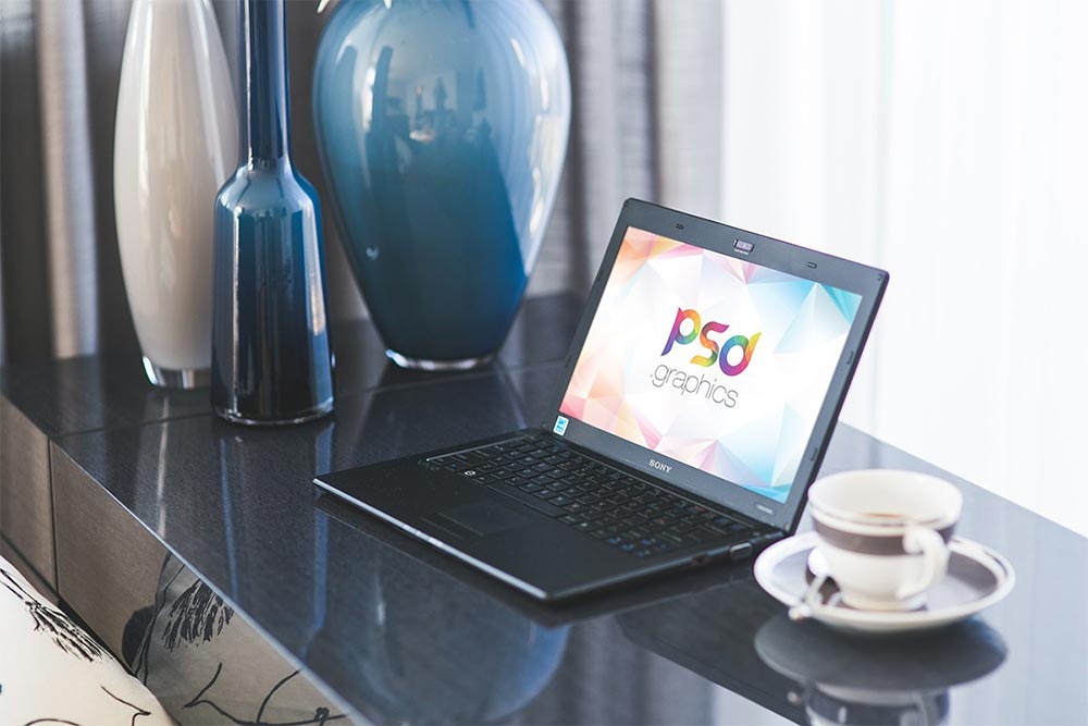 A black laptop on table Mockup with a cup of tea